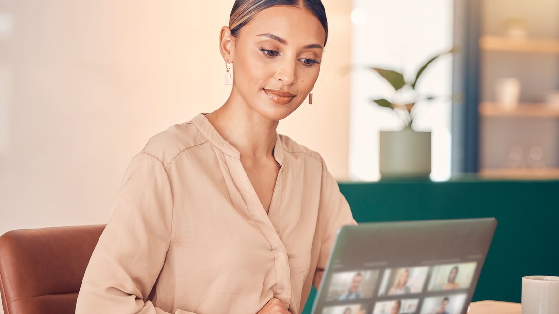 Mujer revisando en su computadora una videollamada con varios participantes — evaluación de desempeño por competencias